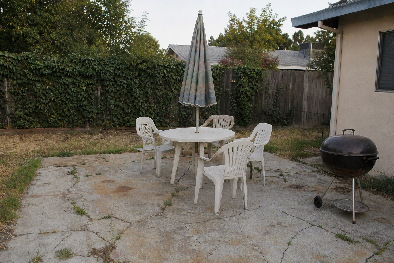 Cracked old concrete patio in Sacramento backyard before remodel